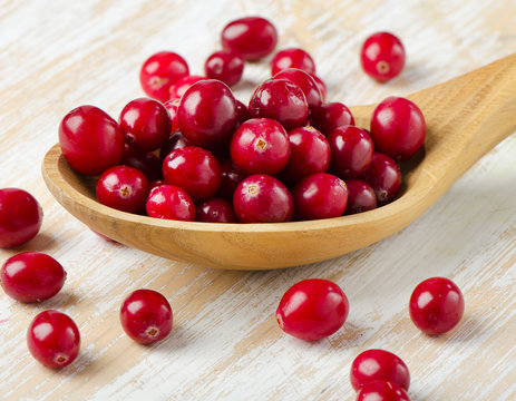 Cranberries in a  wooden spoon