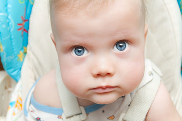 Cute baby boy with big blue eyes looking up