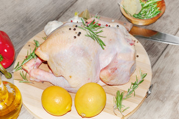 Raw whole chicken on the board