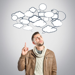 Young man pointing up over grey, background