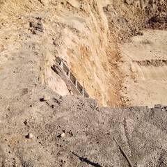 Grube mit Leiter auf Baustelle