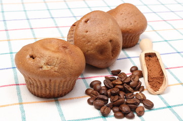 Fresh baked muffins, coffee grains and powdery cinnamon