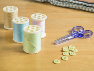 Set of sewing threads and accessories on wooden table