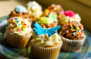 Horizontal colour image of cupcakes on a plate