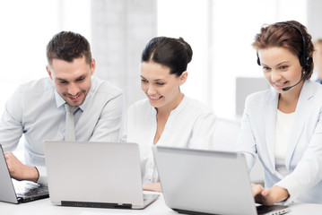 group of people working with laptops in office