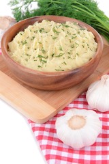 Delicious mashed potatoes with greens in bowl on table close-up