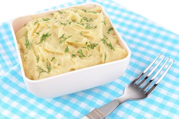 Delicious mashed potatoes with greens in bowl on table close-up