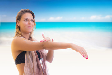 woman applying sunscreen at the beach