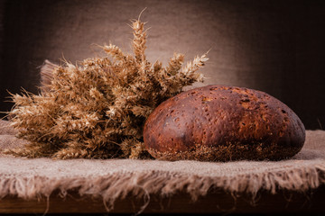 Loaf of bread and rye ears still life