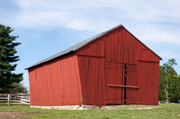 A red barn on a rock foundation.