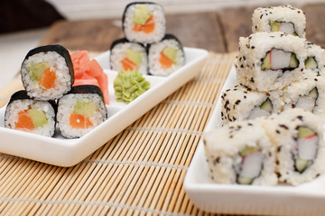 Two different sushi sets on a bamboo mat