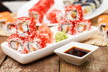 Some sushi and soy sauce in two plates
