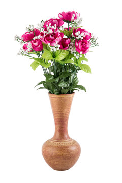 Plastic flowers in a pottery vase isolated on white background.