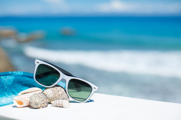 summer concept with sunglasses and seashell on sand