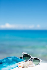 Fototapeta na wymiar summer concept with sunglasses and seashell on sand