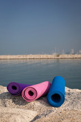 Yoga mats on the beach on the rocks