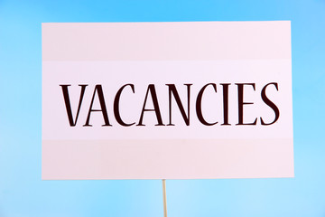 Nameplate with inscription Vacancies on bright background
