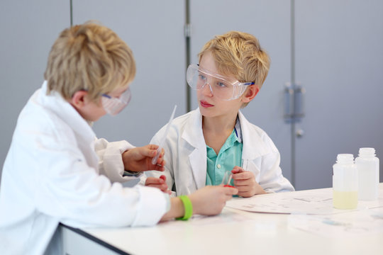 Two school boys making experiments in the chemical laboratory 