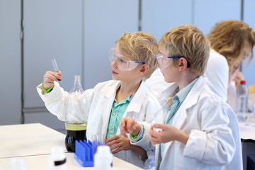 Two school boys making experiments in the chemical laboratory 