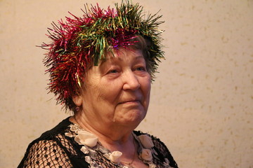 Пожилая женщина  с новогодней мишурой
