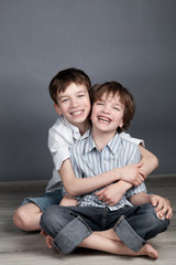 Portrait of two happy brothers on agray background