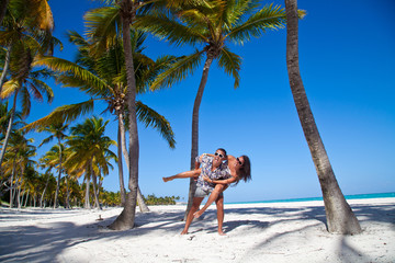 Man giving piggyback ride to girlfriend at the Caribbean beach