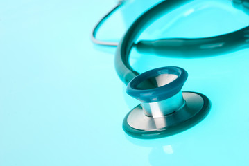 Stethoscope on blue, reflective background