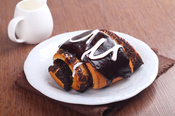 rolls of dough biscuit with poppy seeds and chocolate icing