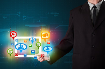 Businessman presenting modern tablet with colorful social signs