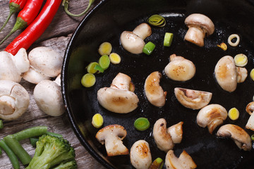 fried mushrooms with leeks in the pan. Top view