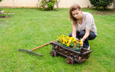 Young woman planting flowers in the garden
