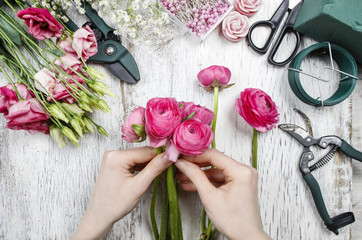 Florist at work. Woman making beautiful bouquet of pink persian