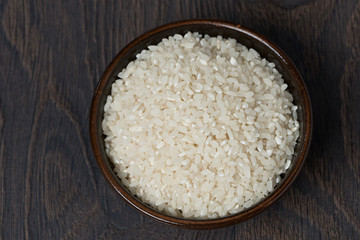 Fototapeta na wymiar white rice in a bowl on dark background, top view