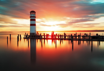 Naklejka premium Beach sunrise with lighthouse