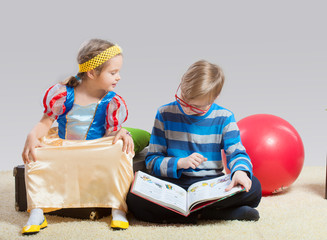 Older brother reading a fairy tale to his little sister