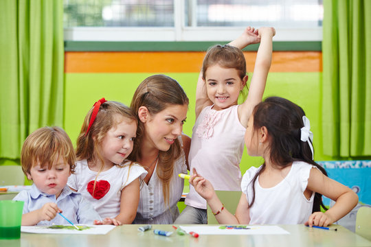 Kinder reden mit Erzieher im Kindergarten