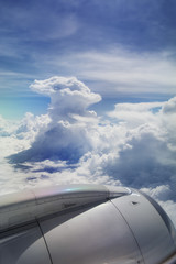 Fototapeta na wymiar View of jet plane wing with giant cloud