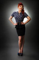 Full length portrait of a pin up girl posing with hands on waist