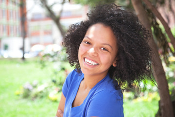 Caribbean girl in blue shirt laughing at camera