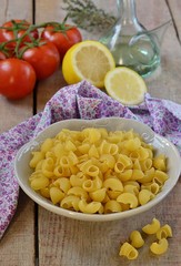 Pasta in a plate with vegetables on a wooden table
