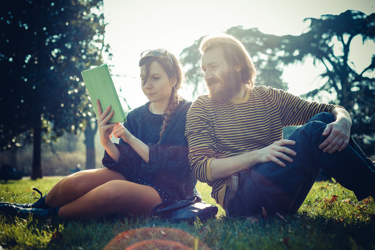 young modern stylish couple using tablet urban