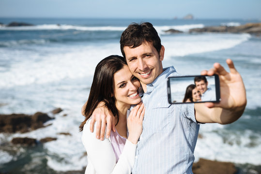 Couple on travel taking smartphone selfie photo