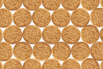 Golden oat biscuit pattern, repeating. Shot from above.