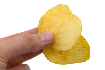 Rippled crisps held between fingers, ready to eat