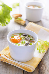 Baked eggs with mushrooms on wooden table