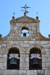 Campanario de piedra con detalle de campanas y veleta