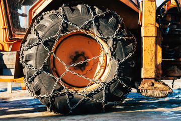 Fototapeta na wymiar Snow chains outside of a tractor tire