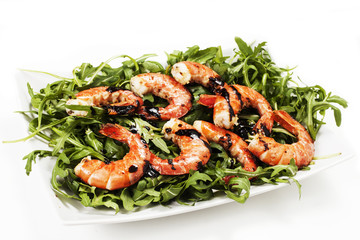 Gamberi con rucola su sfondo bianco