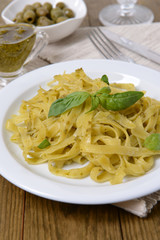 Delicious pasta with pesto on plate on table close-up