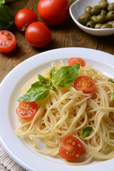 Delicious spaghetti with tomatoes on plate on table close-up